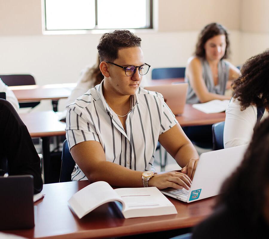 Student takes notes in an engineering concentration in electrical engineering class.